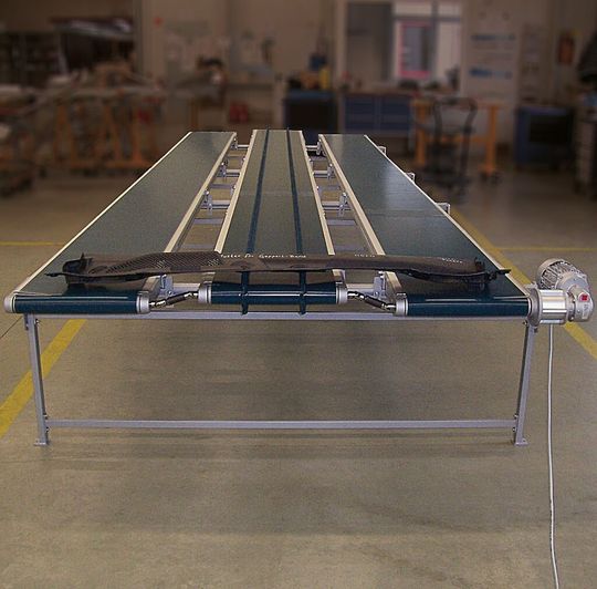 Testphase in der Geppert-Produktion: Ein 2 mm dünnes Spritzgussteil wird mit dem Synchron-Förderband weitertransportiert. Testphase in der Geppert-Produktion: Ein 2 mm dünnes Spritzgussteil wird mit dem Synchron-Förderband weitertransportiert.
