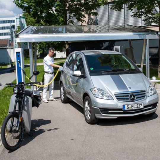 Ein ZSW-Mitarbeiter lädt ein Elektro-Auto am Solar-Carport auf Ein ZSW-Mitarbeiter lädt ein Elektro-Auto am Solar-Carport auf