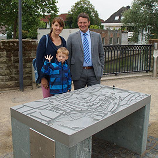 Max Jungeblodt, Geschäftsführer des Ideal-Werks in Lippstadt und Initiator des Projektes, mit Besuchern am Lippstädter Flutmodell. Die Reliefplatte aus Aluminium wurde von AHC technisch eloxiert.