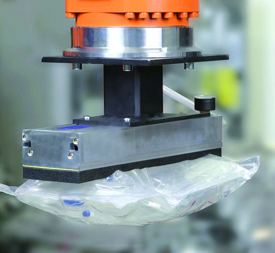 Vakuum-Flächengreifsystem FXC beim Transport eines Infusionsbeutels: Durch die Modularität in Aufbau und Ausstattung kann der Greifer 100%ig an die jeweilige Handhabungsaufgabe angepasst werden. Bild: Schmalz Vakuum-Flächengreifsystem FXC beim Transport eines Infusionsbeutels: Durch die Modularität in Aufbau und Ausstattung kann der Greifer 100%ig an die jeweilige Handhabungsaufgabe angepasst werden. Bild: Schmalz
