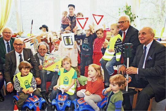 Übergabe der Verkehrsspiele: (Erwachsene v.li.) Herbert Schlickeiser (stellvertretender Obermeister), Norbert Werner (Geschäftsführer der Kfz-Innung), der Erfinder der „Verkehrskiste“, Rudi Wolf, Kölns Bürgermeister Hans-Werner Bartsch und Rolf Mauss (Obermeister).