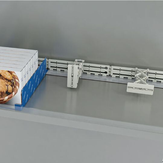 Der neue Warenschieber lässt sich leicht im Regal verschieben und so auf unterschiedliche Produktbreiten und Verpackungen anpassen. Der neue Warenschieber lässt sich leicht im Regal verschieben und so auf unterschiedliche Produktbreiten und Verpackungen anpassen.