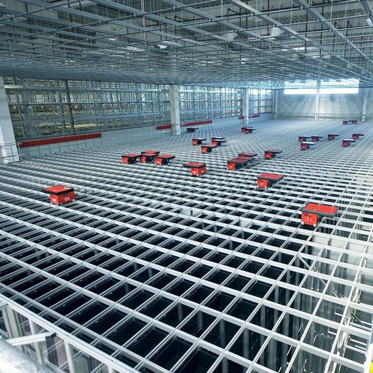 Das Autostore-Grid besteht aus einer selbsttragenden Aluminiumstruktur, die in rechteckige Felder unterteilt ist. Jedes Feld bietet Raum für einen Behälterstapel. Das Autostore-Grid besteht aus einer selbsttragenden Aluminiumstruktur, die in rechteckige Felder unterteilt ist. Jedes Feld bietet Raum für einen Behälterstapel.