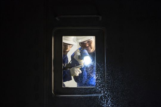 Zwei BASF-Mitarbeiter bei der Produktprüfung durch das Kontrollfenster eines Wirbelschichttrockners im BASF-Flockungsmittelwerk in Nanjing/China Zwei BASF-Mitarbeiter bei der Produktprüfung durch das Kontrollfenster eines Wirbelschichttrockners im BASF-Flockungsmittelwerk in Nanjing/China