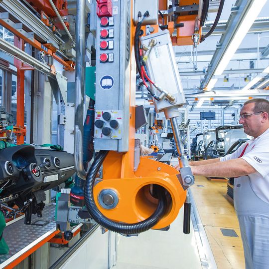 Bild 1: Mit dem Handhabungsgerät kann der Werker das Cockpit praktisch schwerelos transportieren und dann genau im Fahrzeug positionieren. Bild 1: Mit dem Handhabungsgerät kann der Werker das Cockpit praktisch schwerelos transportieren und dann genau im Fahrzeug positionieren.
