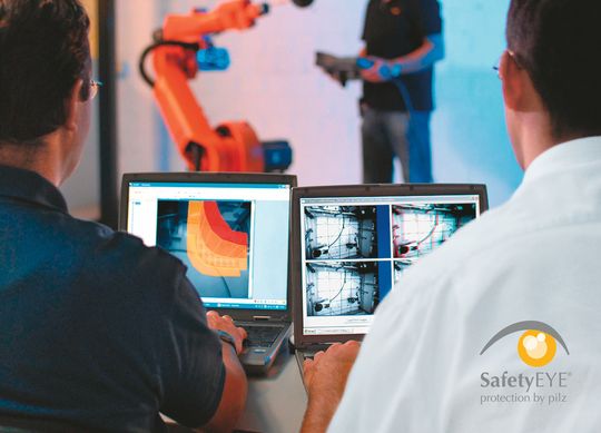 Tritt ein Werker – wie hier zu Demonstrationszwecken – in den als Schutzraum definierten Aktionsbereich eines Roboters, veranlasst das Sicherheitssystem den sofortigen Not-Halt. Tritt ein Werker – wie hier zu Demonstrationszwecken – in den als Schutzraum definierten Aktionsbereich eines Roboters, veranlasst das Sicherheitssystem den sofortigen Not-Halt.