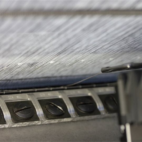 Einbringen der elektrisch leitfähigen Fäden in den Maschenbildungsprozess. Einbringen der elektrisch leitfähigen Fäden in den Maschenbildungsprozess.