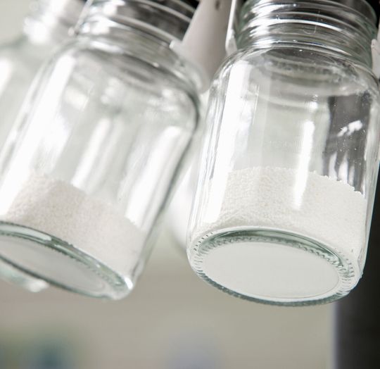 Ein Mitarbeiter im Testlabor für maschinelle Geschirreinigung, füllt Spülmittelpulver über einen Probenteiler ab. Das Spülmittel enthält unter anderem den Komplexbildner Trilon M. Trilon M kann zusammen mit anderen Inhaltsstoffen Phosphat in Spülmaschinenprodukten vollständig ersetzen.