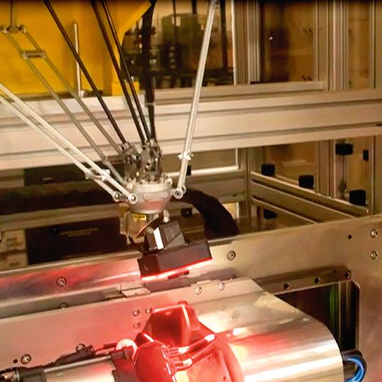 Bild 1: Der Deltaroboter führt die Kamera über das Bauteil. Dabei ist die Kamera in die Robotersteuerung integriert. Bild 1: Der Deltaroboter führt die Kamera über das Bauteil. Dabei ist die Kamera in die Robotersteuerung integriert.