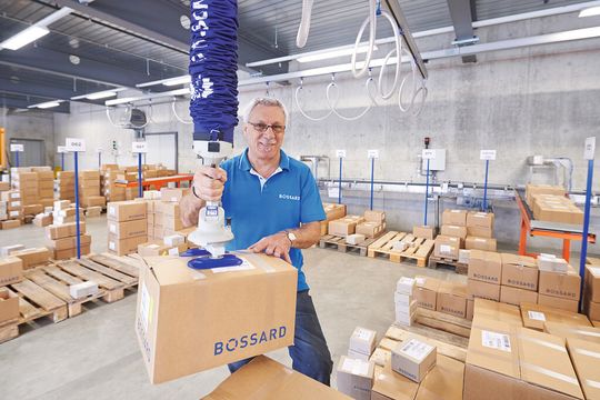 Verbindungstechnik-Spezialist Bossard setzt beim Kommissionieren von Paketen einen Vakuum-Schlauchheber JumboFlex 35 von Schmalz ein. Verbindungstechnik-Spezialist Bossard setzt beim Kommissionieren von Paketen einen Vakuum-Schlauchheber JumboFlex 35 von Schmalz ein.