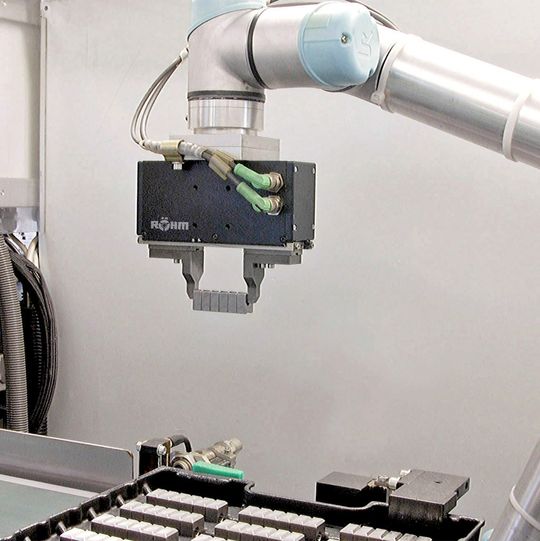 Bild 1: Hat der Elektrogreifer Werkstücke auf der Schiene zwischenplatziert, packt er die ganze Reihe und setzt sie in eine vorbereitete Versandpalette. Bild 1: Hat der Elektrogreifer Werkstücke auf der Schiene zwischenplatziert, packt er die ganze Reihe und setzt sie in eine vorbereitete Versandpalette.