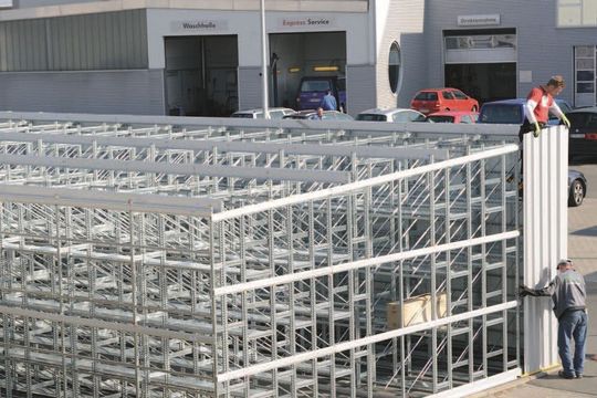 Die Cover-Halle ummantelt wie das Cover einer CD das Räderregal. Die Trapezblechverkleidung befestigen die Monteure an die Verbindungsrahmen. Bei Bedarf lässt sich die Schnellbauhalle erweitern.