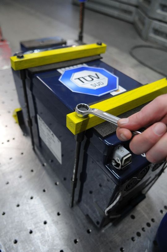 TÜV SÜD: Eine Batterie wird für einen Crashtest auf einem Versuchsschlitten fixiert. TÜV SÜD: Eine Batterie wird für einen Crashtest auf einem Versuchsschlitten fixiert.