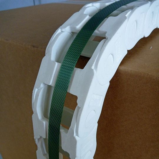 Bei der neuen Kette wird das Band durch eine eingearbeitete Nut auf der Rückseite jedes Kettengliedes mittig auf der Kette gehalten. Bei der neuen Kette wird das Band durch eine eingearbeitete Nut auf der Rückseite jedes Kettengliedes mittig auf der Kette gehalten.