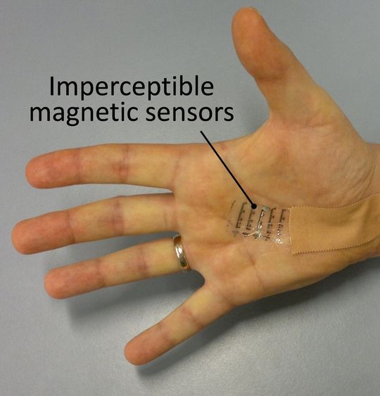 Unauffälliger Magnetsensor auf einer Handfläche. Ein Element ist mit dem Ausleseschaltkreis verbunden. Unauffälliger Magnetsensor auf einer Handfläche. Ein Element ist mit dem Ausleseschaltkreis verbunden.