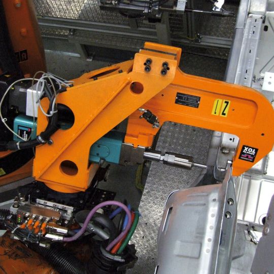 Eine Roboterzange setzt ein Tox-Rund-Punkt. Eine Roboterzange setzt ein Tox-Rund-Punkt.