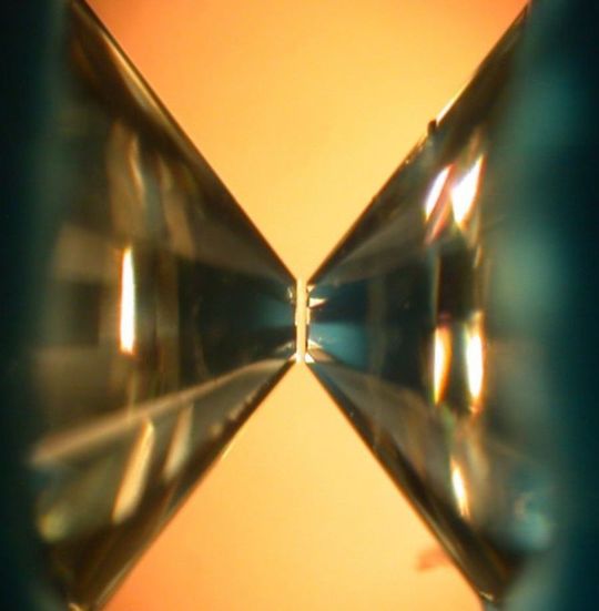 Blick ins Innere einer Diamantstempelzelle mit den einander gegenüberliegenden Diamanten zwischen denen die Kristalle extrem hohen Drücken von fast 100 Gigapascal ausgesetzt wurden. Blick ins Innere einer Diamantstempelzelle mit den einander gegenüberliegenden Diamanten zwischen denen die Kristalle extrem hohen Drücken von fast 100 Gigapascal ausgesetzt wurden.