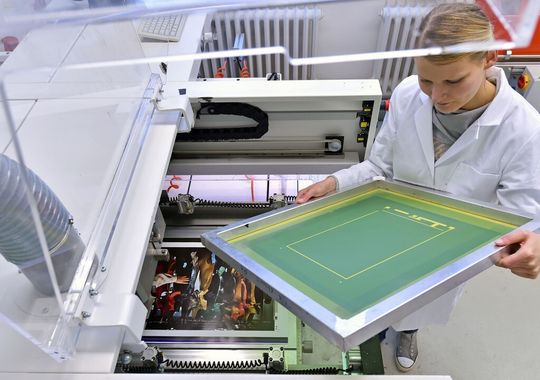 Marlene Klüßendorf, die an der TU Chemnitz Print- und Medientechnik studiert, prüft die Qualität des Siebes für den Lautsprecherdruck. Marlene Klüßendorf, die an der TU Chemnitz Print- und Medientechnik studiert, prüft die Qualität des Siebes für den Lautsprecherdruck.