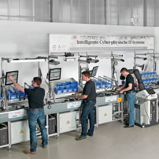 Bild 1: Im cyber-physischen Montagesystem mit modularem und rekonfigurierbarem Aufbau sind die Stationen durch ein integriertes Transportsystem miteinander verkettet. Bild 1: Im cyber-physischen Montagesystem mit modularem und rekonfigurierbarem Aufbau sind die Stationen durch ein integriertes Transportsystem miteinander verkettet.