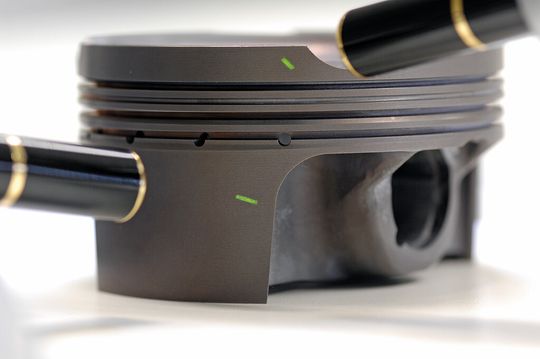 Chemisch abgeschiedene Nickelschicht mit PTFE-Markern auf einem Aluminiumkolben. Chemisch abgeschiedene Nickelschicht mit PTFE-Markern auf einem Aluminiumkolben.
