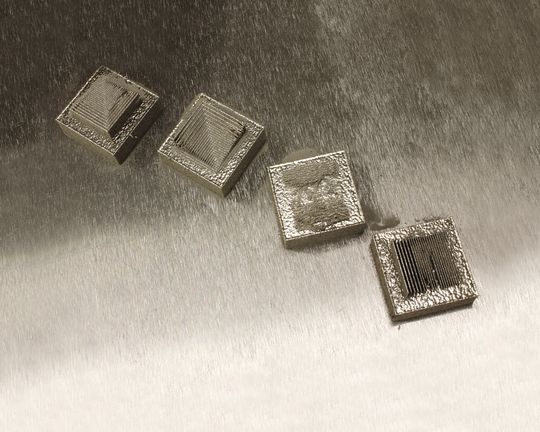 One of two illustrations of the effect of part orientation. The part below was produced by three different additive manufacturing suppliers. The components they delivered were all different, because each supplier chose to orient the part in a different way. At right, delicate features are produced with differing levels of success depending on their orientation with respect to the machine’s moving blade. One of two illustrations of the effect of part orientation. The part below was produced by three different additive manufacturing suppliers. The components they delivered were all different, because each supplier chose to orient the part in a different way. At right, delicate features are produced with differing levels of success depending on their orientation with respect to the machine’s moving blade.