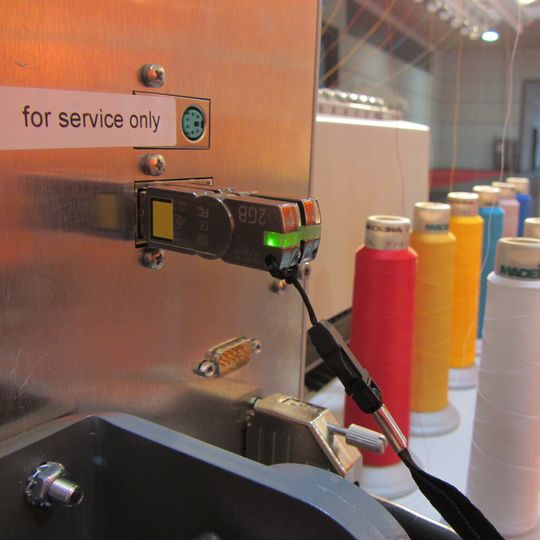 Stickmaschine von hinten: Die Schutzhardware CmDongle steckt auf einer Stickmaschine und schützt und lizenziert Embedded-Software. Stickmaschine von hinten: Die Schutzhardware CmDongle steckt auf einer Stickmaschine und schützt und lizenziert Embedded-Software.