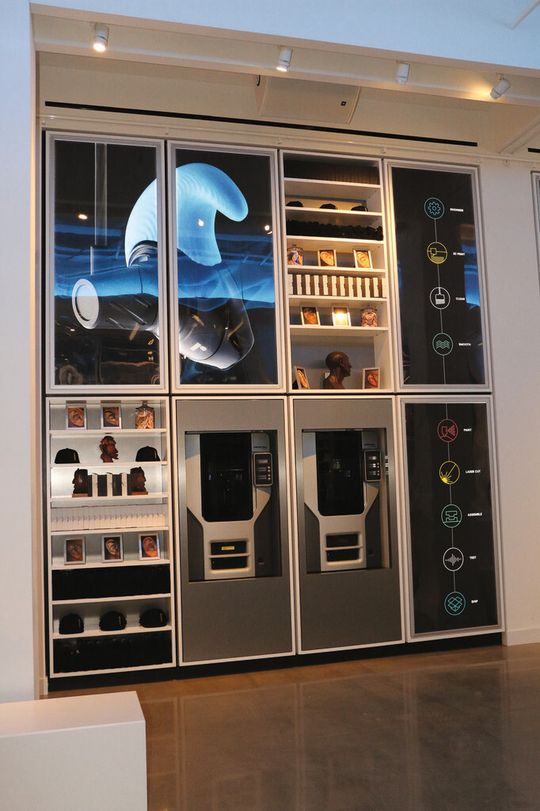 Ein Ausstellungsbereich mit zwei Stratasys 3D-Druckern. Insgesamt zehn 3D-Drucker sind in die Innenausstattung des Ladens integriert. Ein Ausstellungsbereich mit zwei Stratasys 3D-Druckern. Insgesamt zehn 3D-Drucker sind in die Innenausstattung des Ladens integriert.
