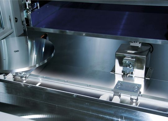 Die tellerförmigen Werkstückträger laufen bei automatischer Serienkennzeichnung auf der Curviline-Führung in die Anlage Die tellerförmigen Werkstückträger laufen bei automatischer Serienkennzeichnung auf der Curviline-Führung in die Anlage