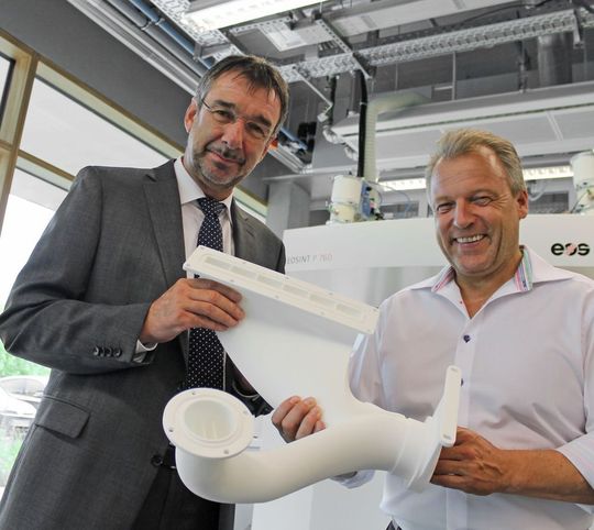 Liegt gut in der Hand und im Trend: Im Vorfeld der formnext 2015 überzeugt sich Uwe Behm (links), Geschäftsführer der Messe Frankfurt, bei EOS in Krailling bei München von den großartigen Möglichkeiten, die Additive Fertigung für die Industrie bietet. Udo Behrendt, Key Account Manager Aerospace bei EOS, präsentiert ein 3D-gedrucktes Kunststoffbauteil, das EOS selbst in seinen Anlagen verwendet. Liegt gut in der Hand und im Trend: Im Vorfeld der formnext 2015 überzeugt sich Uwe Behm (links), Geschäftsführer der Messe Frankfurt, bei EOS in Krailling bei München von den großartigen Möglichkeiten, die Additive Fertigung für die Industrie bietet. Udo Behrendt, Key Account Manager Aerospace bei EOS, präsentiert ein 3D-gedrucktes Kunststoffbauteil, das EOS selbst in seinen Anlagen verwendet.