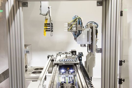 Entnahme der Pipettenspitzen aus dem Werkzeug: Der spezielle Greifer des Robot-Systems (im Bild links) übergibt die Teile an die zweite Fixierstation außerhalb des Werkzeugbereichs. Entnahme der Pipettenspitzen aus dem Werkzeug: Der spezielle Greifer des Robot-Systems (im Bild links) übergibt die Teile an die zweite Fixierstation außerhalb des Werkzeugbereichs.