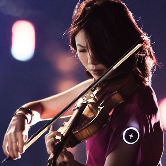 Der Soundbrenner Pulse, den diese Geigerin am Arm trägt, ersetzt ein konventionelles Metronom. Da sich bis zu zehn Geräte per App verbinden lassen, ist es möglich, einer Band oder einem kleinen Orchester einen synchronen Takt zu übermitteln.