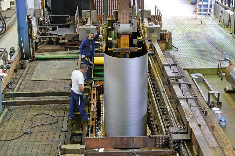 Bild 1: Ein Endlosband wird in ein Chrombad zur technischen Hartverchromung per Kran zugeführt. Diese Bänder zeigen sich verantwortlich zur Herstellung von Möbelfurnieren und Laminatböden. HCWB AG ist das einzige Unternehmen weltweit, welches in der Lage ist, solche Bänder mit Hartchrom zu beschichten.