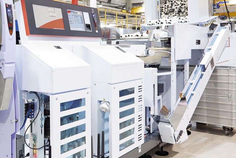 Zuführung von Kopsen (speziellen Kunststoffhülsen mit Ringgarn) in der Spulmaschine Autoconer 6 von Schlafhorst.
