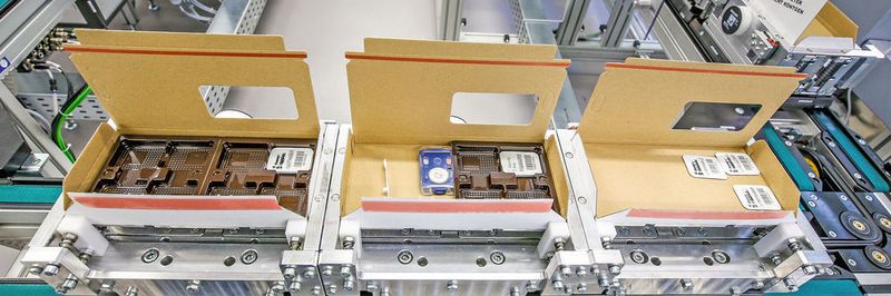 Teilgefüllte Packungen auf dem Transportweg durch die Versandanlage.