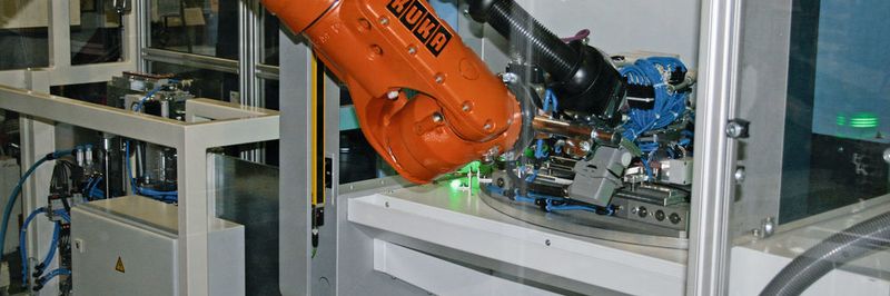 In einem ersten Bearbeitungsschritt werden die Platinen auf die Aufnahme eines Laserrundschalttischs aufgelegt. Dort wird simultan auf beiden Platinen der Schriftzug des Automobilherstellers mittels Laser eingeschnitten.