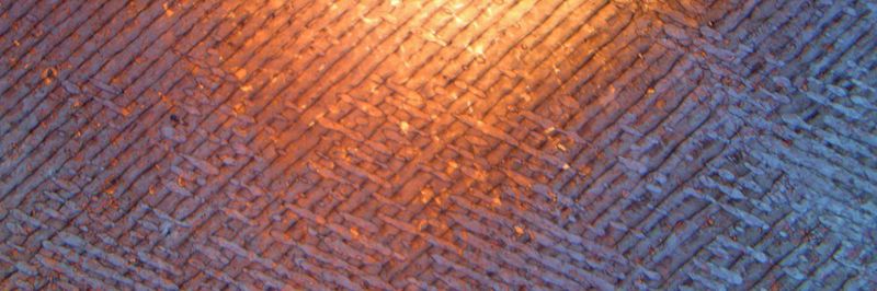 An der Bauteiloberfläche ist die Aufbaustrategie durch kreuzweises Übereinanderlegen von Schichten aus Schweissraupen deutlich zu erkennen.