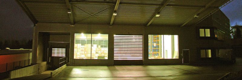 Große Fenster und Klarsichtlamellen im Rolltor bringen viel Tageslicht in die Lagerhalle von USD Formteiltechnik.