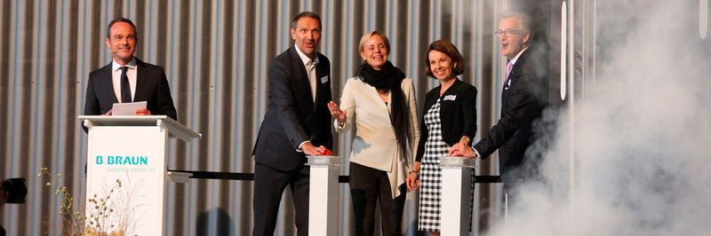 Eröffnung mit Schall und Rauch: Group Senior Vice President CoE IV-Systems Jürgen Stihl, CEO Madeleine Stöckli, Verwaltungsrätin Anne Schwöbel und Plant Manager Reinhold Gasper (v.r.n.l.) nehmen die neue Produktionsstätte in Betrieb. Links im Bild: Moderator Oliver Haindl