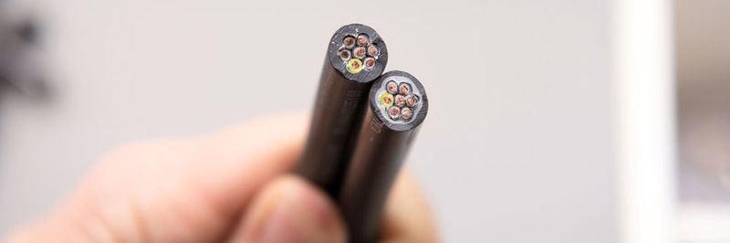 Bei herkömmlichen Leitungen besteht die Zwickelfüllung aus dem gleichen Material wie der Außenmantel (li. oben). Bei den neuen Steuerleitungen von Lapp besteht die innere Zwickelfüllung aus einem anderen Matrial (r. unten).