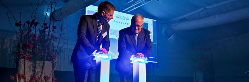 Bundespräsident Johann Schneider-Ammann und PSI-Direktor Joël Mesot drücken die roten Knöpfe.