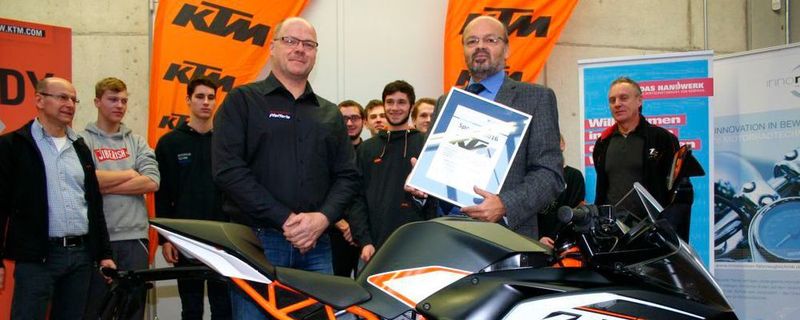 Kai Armin Pfefferle (vorne l.) als Vertreter von KTM erhielt für die Spende des Motorrads eine Sponsorenurkunde von Gerhard Bärmann (vorne r.), Fachbereichskoordinator überbetriebliche Ausbildung an der Gewerbe Akademie. Ralf Maier (hinten l.), Fachbereichsleiter Abteilung Fahrzeugtechnik der Gewerbe Akademie, die Auszubildenden zum Zweiradmechatroniker Fachrichtung Motorrad im 3. Lehrjahr und Horst Rudlof (hinten r.), Ausbildungsmeister für Motorradtechnik, freuen sich über den Zugang im Fuhrpark.