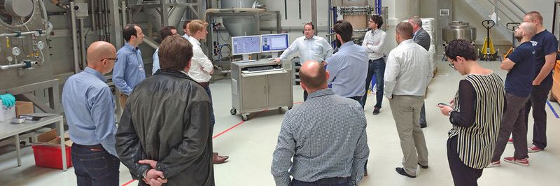Ein Vertreter von Zeppelin erklärt die Fertigungsanlage für die Back- und Süßwarenproduktion. Aufmerksame Zuhörer sind die Vertreter der drei Softwareunternehmen.