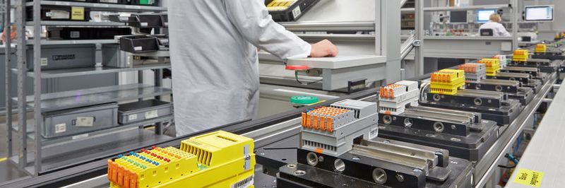 Die modular aufgebaute Produktionslinie integriert manuelle Arbeitsplätze für Montageaufgaben und automatisierte Prozessmodule für Beschriftungs- sowie Prüfprozesse.