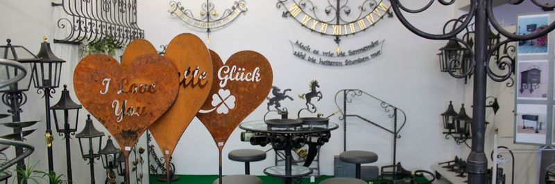 Eine kleine Auswahl an metallischen Kunsthandwerkprodukten sowie individuell ausgeführte schmiedeeiserne Fenstergitter, Lampen und Sonnenuhren.
