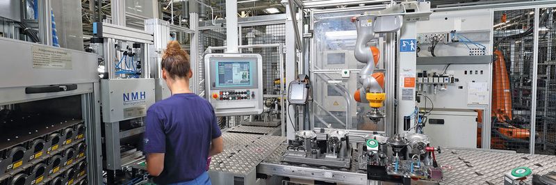 Die Anlage musste sich räumlich in die Produktionslinie einfügen. Dafür entwickelte Kuka Systems eine Stahlbaukonstruktion in Form eines Galgens, an der ein feinfühliger Leichtbauroboter befestigt ist. Der LBR iiwa kann so hängend arbeiten und nimmt wenig Platz in Anspruch.