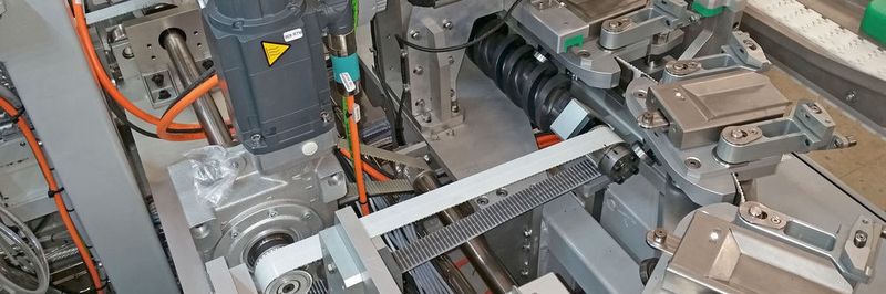 Der DTS2-Schneckenantrieb über der schwarzen Spindel (links), beschleunigt von einem Siemens-Elektromotor (rechts), bringt bei Colin Mear Behälter in Position.