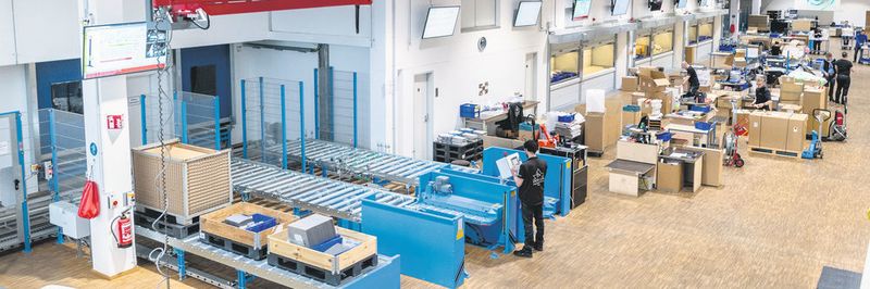 Das neue Lager für Versand und Produktion im Überblick: vorne die Kommissionierstiche des Paletten- Hochregallagers, daran anschließend sechs Lagerlifte des Typs Shuttle XP 500 für die Lagerung und Bereitstellung von Kleinteilen.