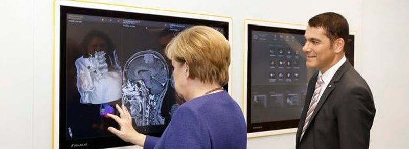 Bundeskanzlerin Angela Merkel (links) testet mit Stefan Vilsmeier, Gründer und CEO von Brainlab, softwaregestützte Medizintechnik in der neuen Firmenzentrale des Unternehmens in München.
