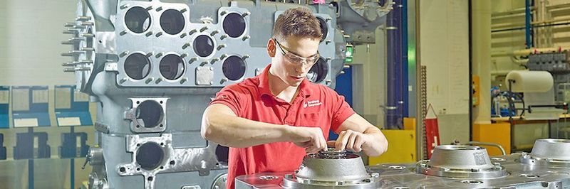 Der heutige Polymechaniker/in im Fachbereich Fertigung produziert grosse und kleine Maschinenelemente für das Endprodukt. Im Bild ein Auszubildender bei Burkhalter Compression.