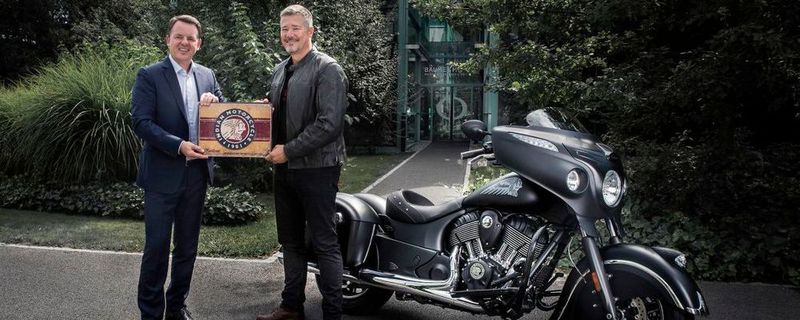 Alain Zimmermann, CEO von Baume & Mercier (links) und Grant Bester, Vice President von Indian Motorcycle EMEA mit einer Indian Chieftain Dark Horse vor dem Firmensitz des Uhrenherstellers in Genf, Schweiz.